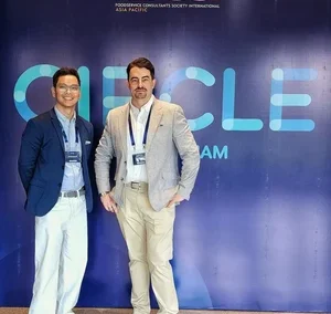 Two men posing in front of CIRCLE 2025 backdrop at FCSI Asia Pacific event.