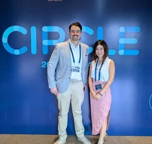 Two smiling attendees posing in front of CIRCLE 2025 event backdrop.