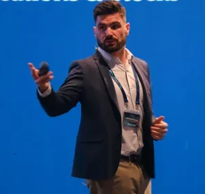 Confident speaker gesturing while presenting at CIRCLE 2025 conference.